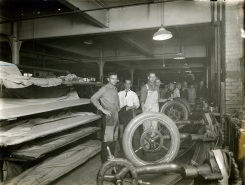 ROW OF HAND BUILDING TIRE STANDS - The larger sizes of fabric Tires are made wholly by hand. Here the fabric is laid and stretched, ply by ply, over iron cores.